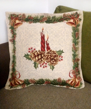 Коледна калъфка със запалена свещичка сред елхови клонки